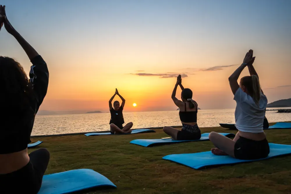 Gün doğumunda deniz kıyısında yoga